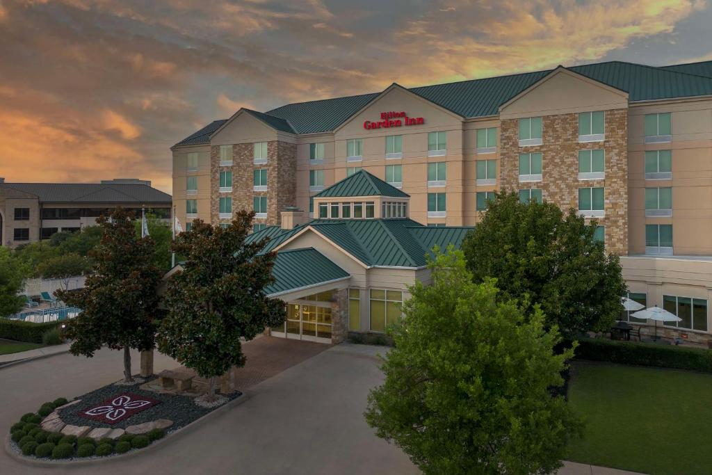 a rendering of a hotel building with trees in front at Hilton Garden Inn Frisco in Frisco