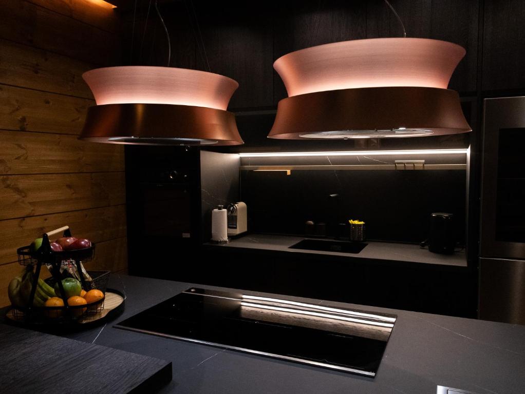 een keuken met koperen verlichting en een aanrecht met spoelbak bij The Ski Room Sierra Nevada in Sierra Nevada