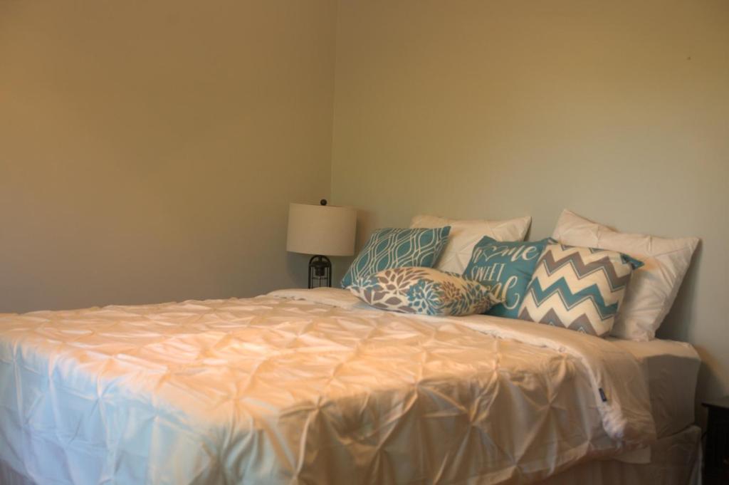 a bedroom with a bed with pillows on it at Rest & Relax in our cozy 5 Bedroom House in Browns Mill Lake