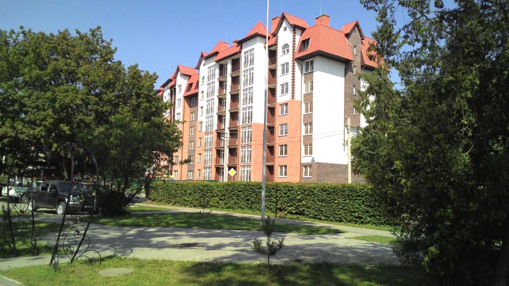 スヴェトロゴルスクにあるApartment U Ozeraの赤い屋根の大きなアパートメントビル
