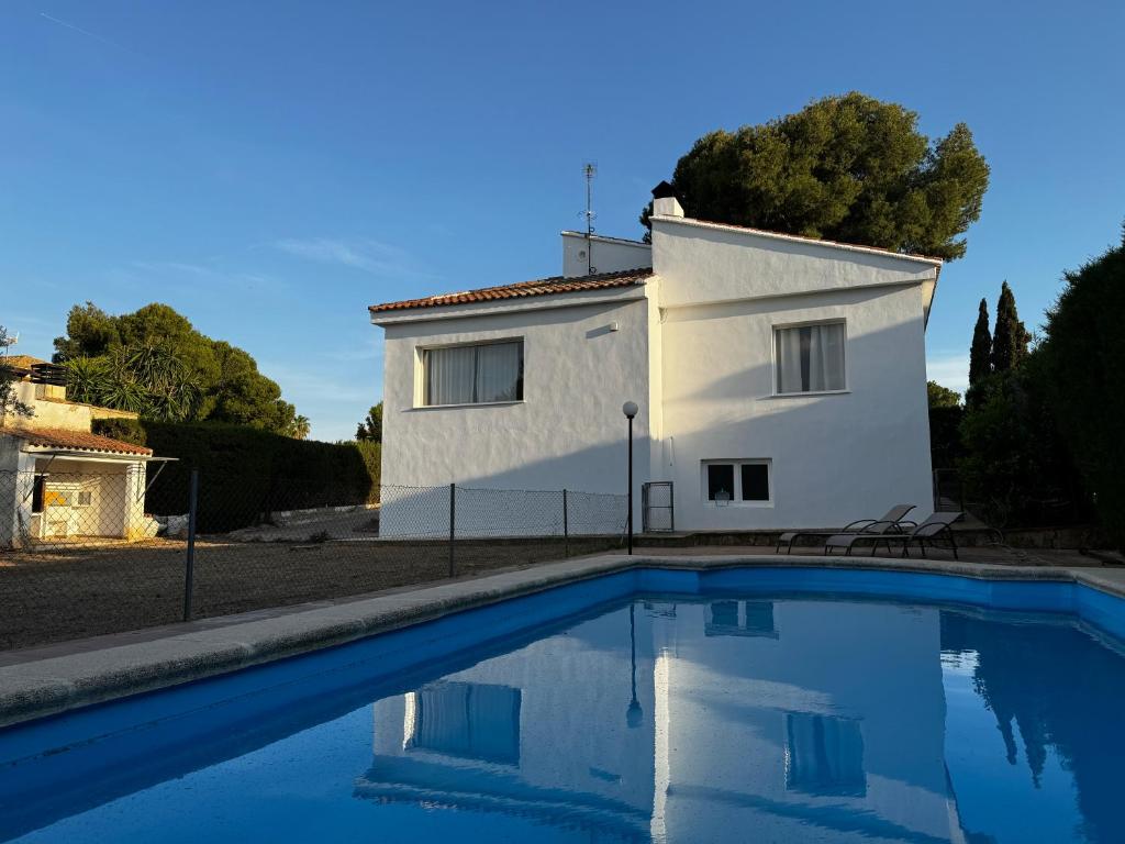 ein weißes Haus mit einem Swimmingpool davor in der Unterkunft Acogedora casa con piscina in Lliria