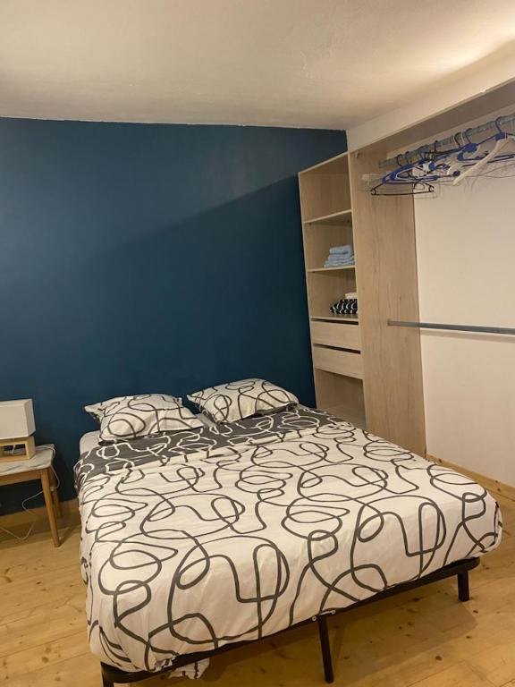 une chambre avec un lit et un mur bleu dans l'établissement Maison de ville, à Niort