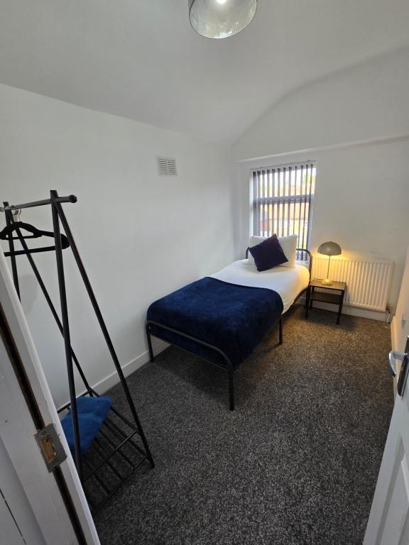 a bedroom with a bed with a blue pillow and a tripod at The Grand four bed getaway- Sleeps 9-free on street parking in Birmingham
