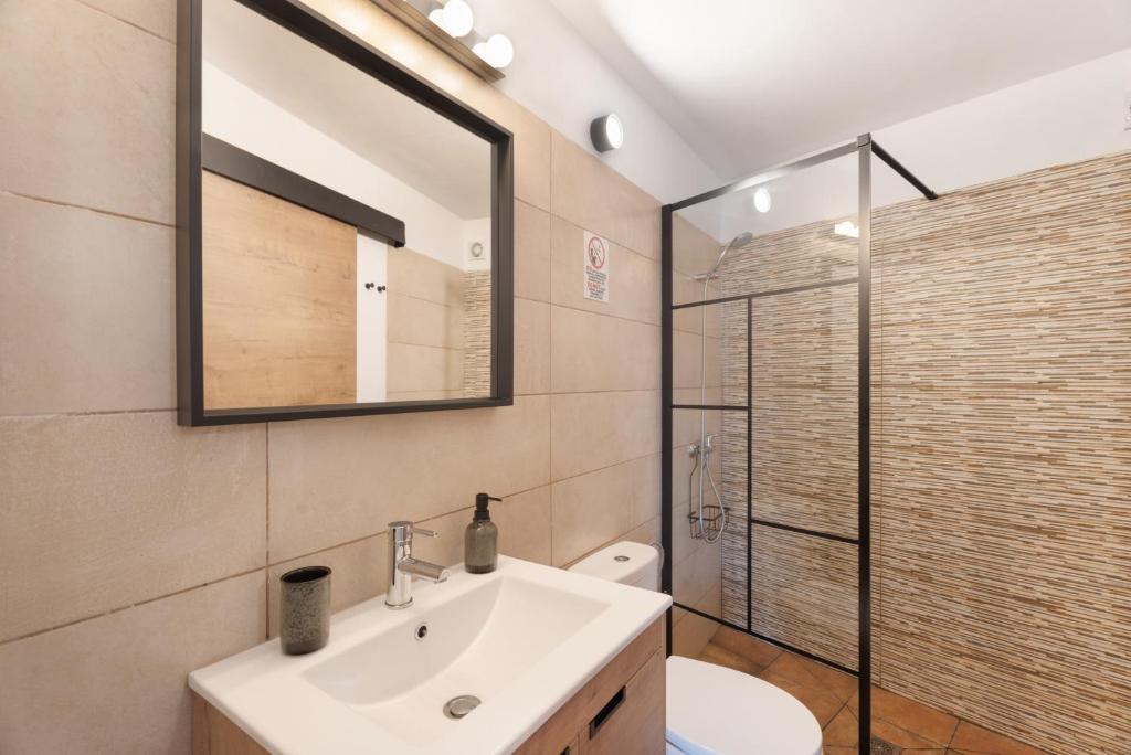 a bathroom with a sink and a mirror and a toilet at Vivienda vacacional La Era I in Vallehermoso