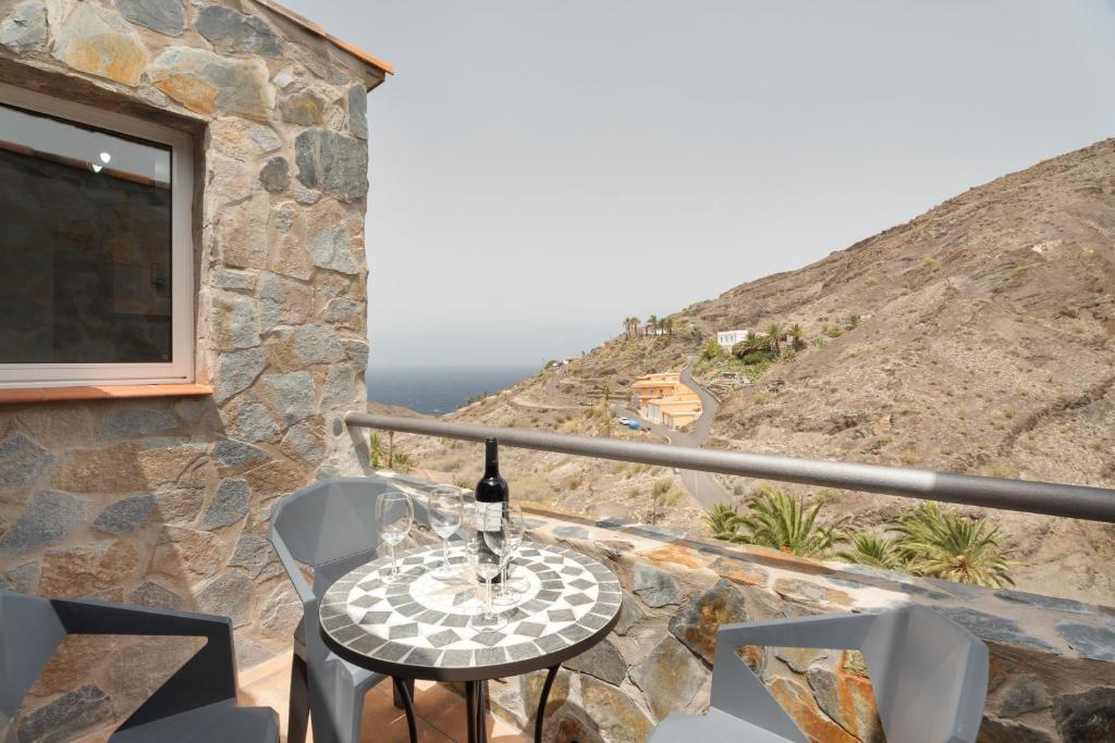 a table with a bottle of wine sitting on a balcony at Vivienda vacacional La Era I in Vallehermoso