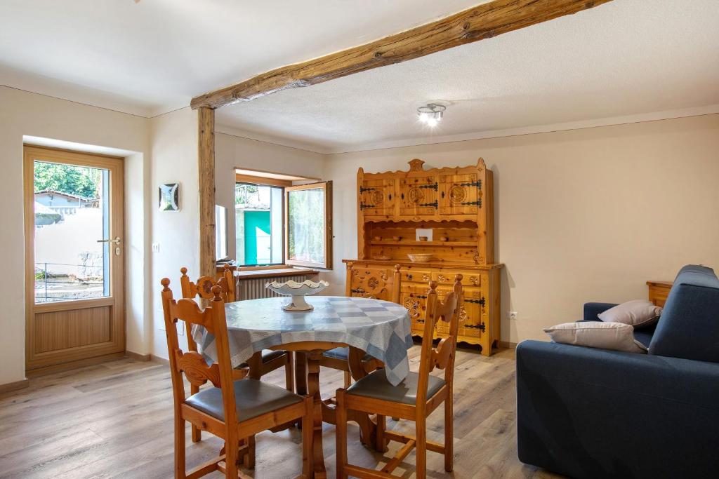 a dining room with a table and chairs and a couch at Maison Marcel Sarre in Aosta