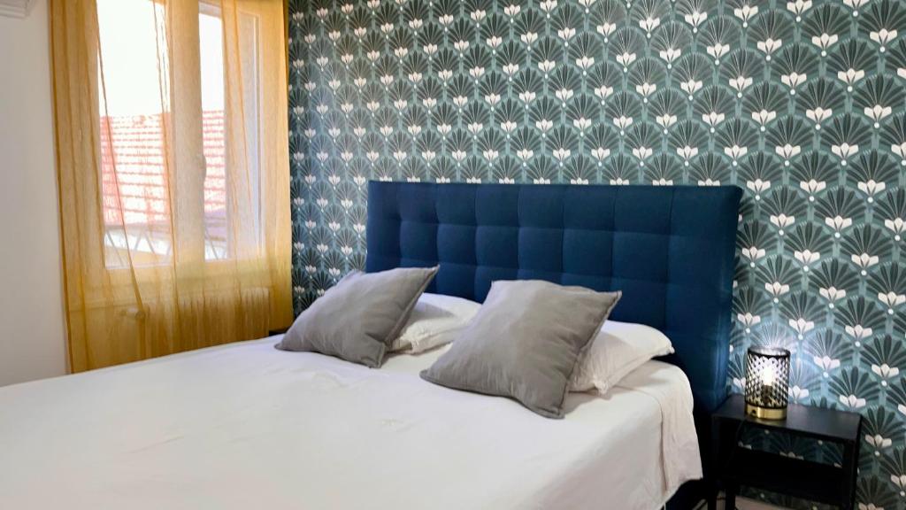 - un lit avec une tête de lit bleue dans une chambre dans l'établissement Europole 2 Gare de Grenoble & centre ville, à Grenoble