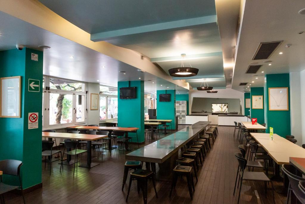 a dining room with green walls and tables and chairs at Plus Florence in Florence