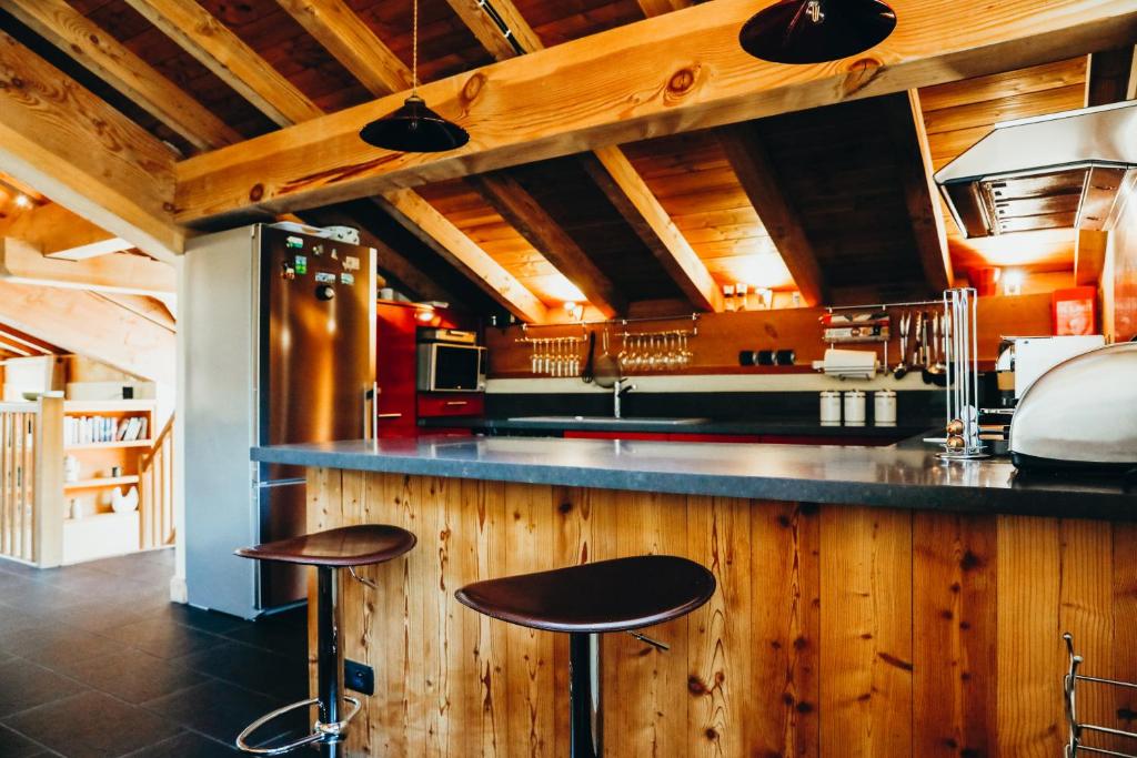 a kitchen with two stools at a kitchen counter at Le Cochet by Lodji in Saint-Martin-de-Belleville