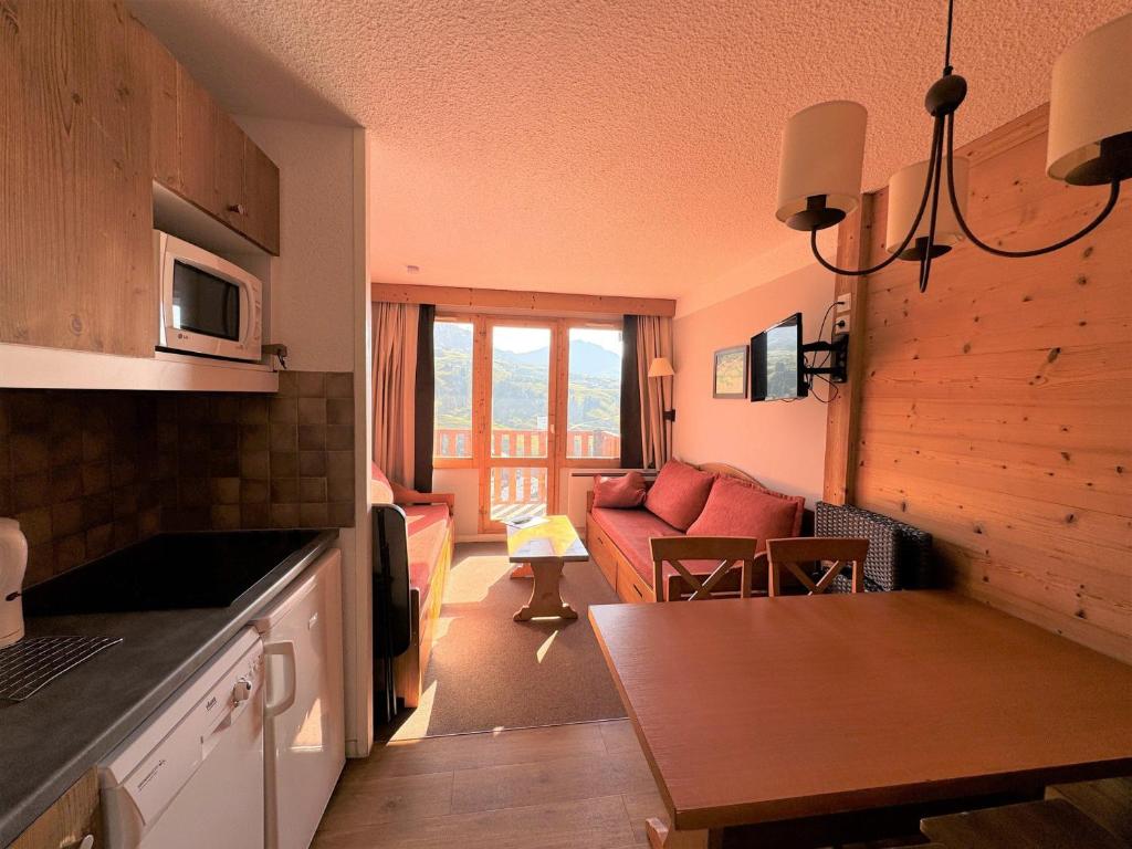 une cuisine et un salon avec un canapé dans l'établissement Studio cabine au pied des pistes avec balcon et casier à skis - FR-1-181-2209, à La Plagne Tarentaise