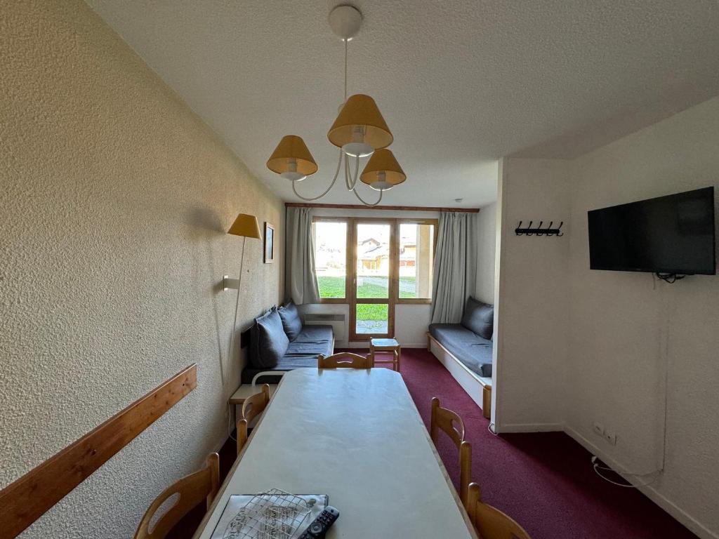 un salon avec une table et un canapé dans l'établissement Appartement au pied des pistes avec WIFI et animaux admis - FR-1-181-2247, à La Plagne Tarentaise