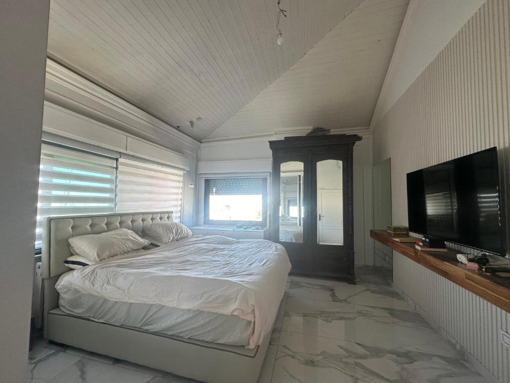 a bedroom with a bed and a flat screen tv at Immaculate apartment in Umm Uthainah