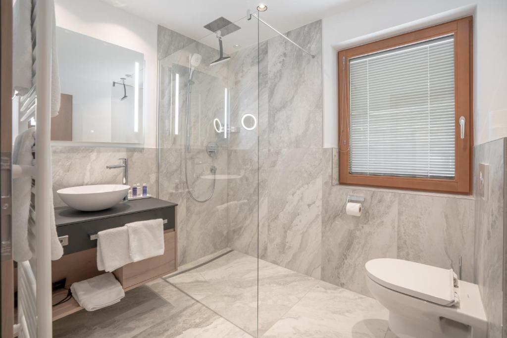 ein Badezimmer mit Dusche, Waschbecken und Toilette in der Unterkunft Chalet Madlein in Ischgl