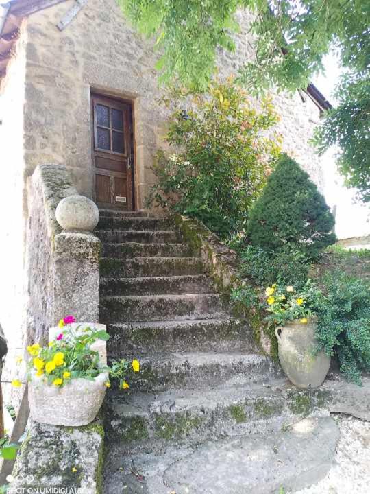 un escalier menant à une maison avec une porte. dans l'établissement Gîtes du GRC, à Campuac