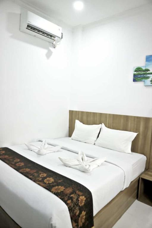 Postel nebo postele na pokoji v ubytování Hotel Bhakti Syariah