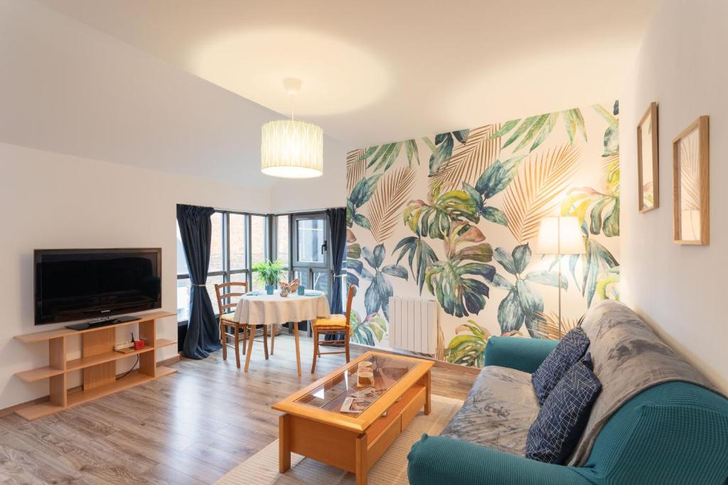 un salon avec un canapé bleu et une table dans l'établissement La Canopée Urbaine - Apt centre-ville avec parking, à Rennes
