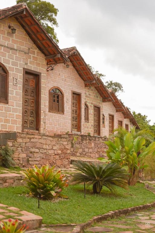 a stone house withtropical plants in front of it at Bosque do Lapão in Lençóis