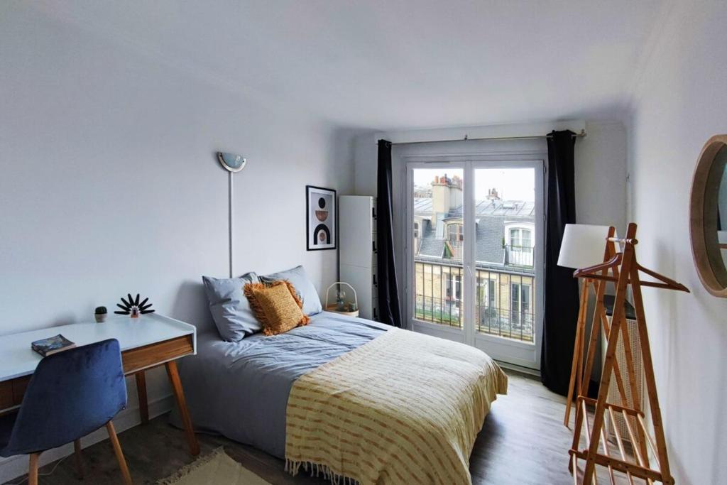 une chambre avec un lit, un bureau et une fenêtre dans l'établissement Flexliving - room - Villon, à Paris
