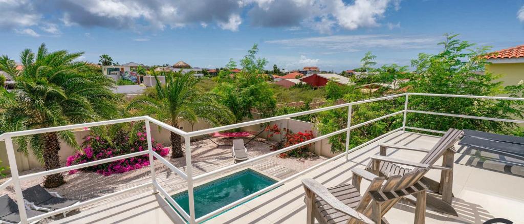 a balcony with two chairs and a swimming pool at Favvidea in Jan Thiel