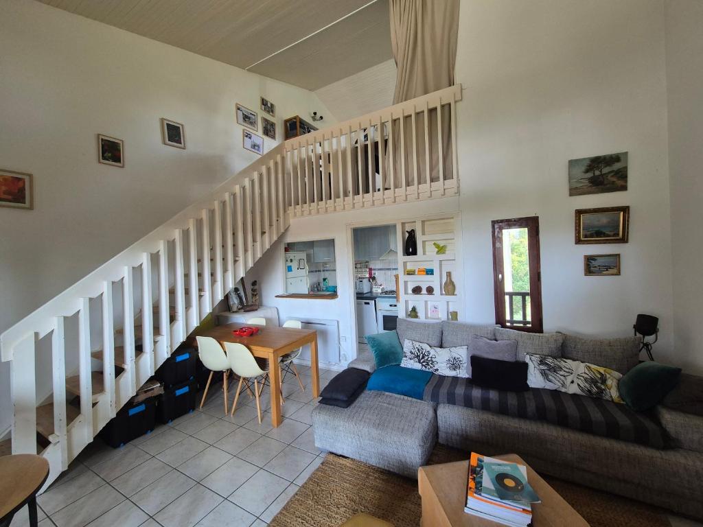 a living room with a couch and a staircase at Seignosse Appart T2 - 500m Océan in Hossegor