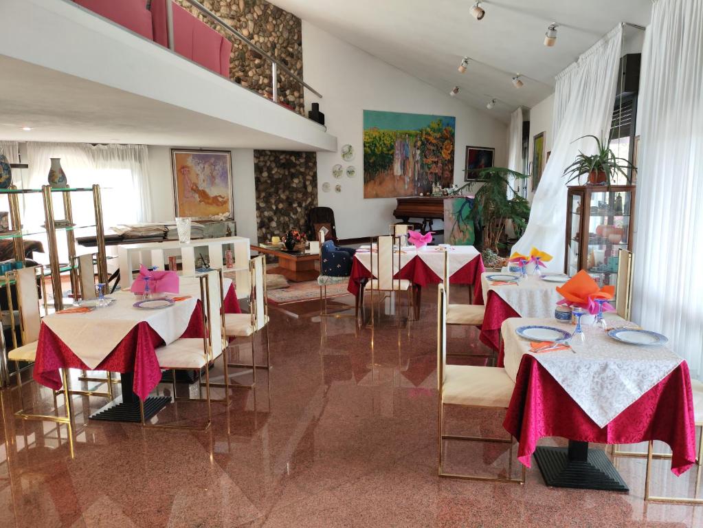 a restaurant with tables and chairs with pink tablecloths at B&B Cà d'Artisti in Caorle