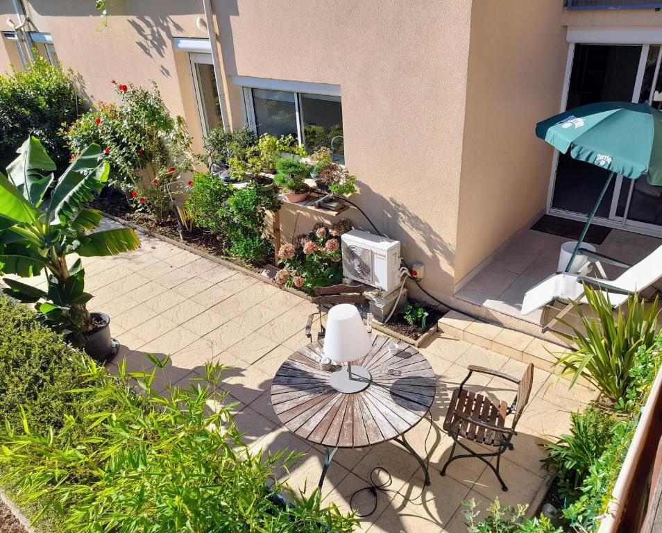 a patio with a table and chairs and an umbrella at Terrasse de Malissol in Vienne