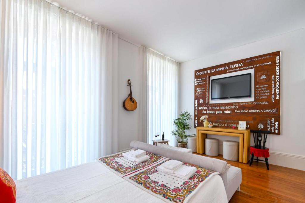 ein Schlafzimmer mit einem Sofa und einem TV an der Wand in der Unterkunft Almada e Fado in Porto