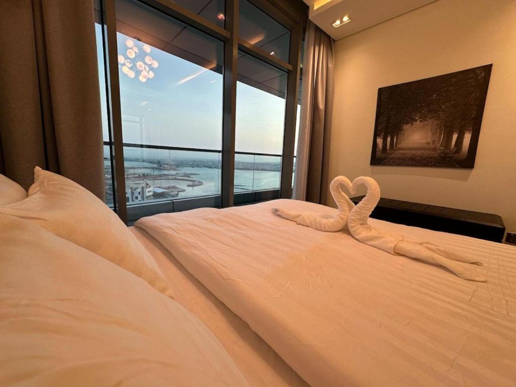 a bed with a heart made out of towels at High Floor 33 Luxury Apartment in Manama