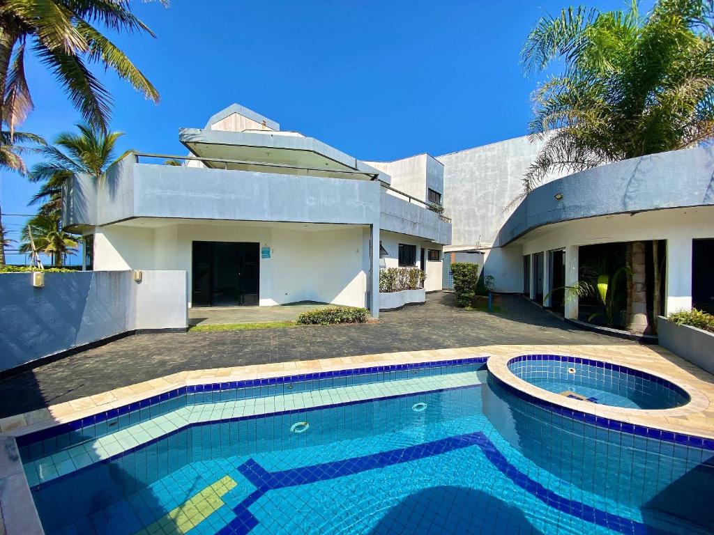a house with a swimming pool in front of a house at Casa Alto Padrão de Frente ao Mar in Peruíbe