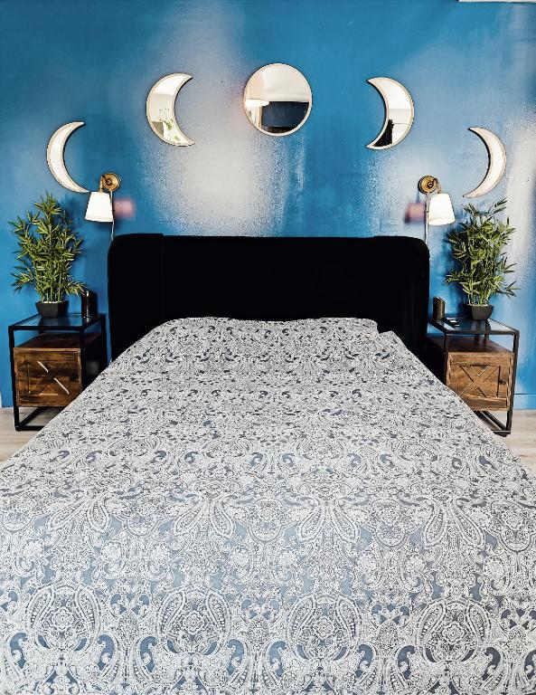 - une chambre dotée d'un grand lit avec des murs et des lumières bleus dans l'établissement Sauna & Détente - Suite Privée - Tours - Netflix, à Tours