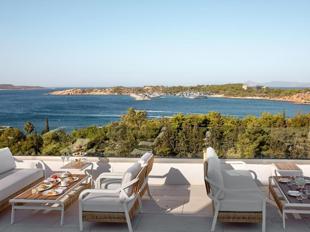 a patio with a view of the water at The Roc Club, A Grecotel Hotel to Live in Athens