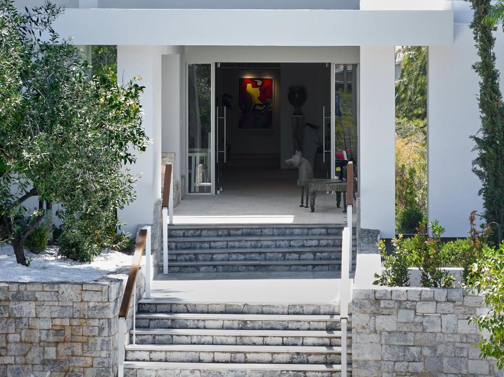 a home with stairs leading to the front door at The Roc Club, A Grecotel Hotel to Live in Athens