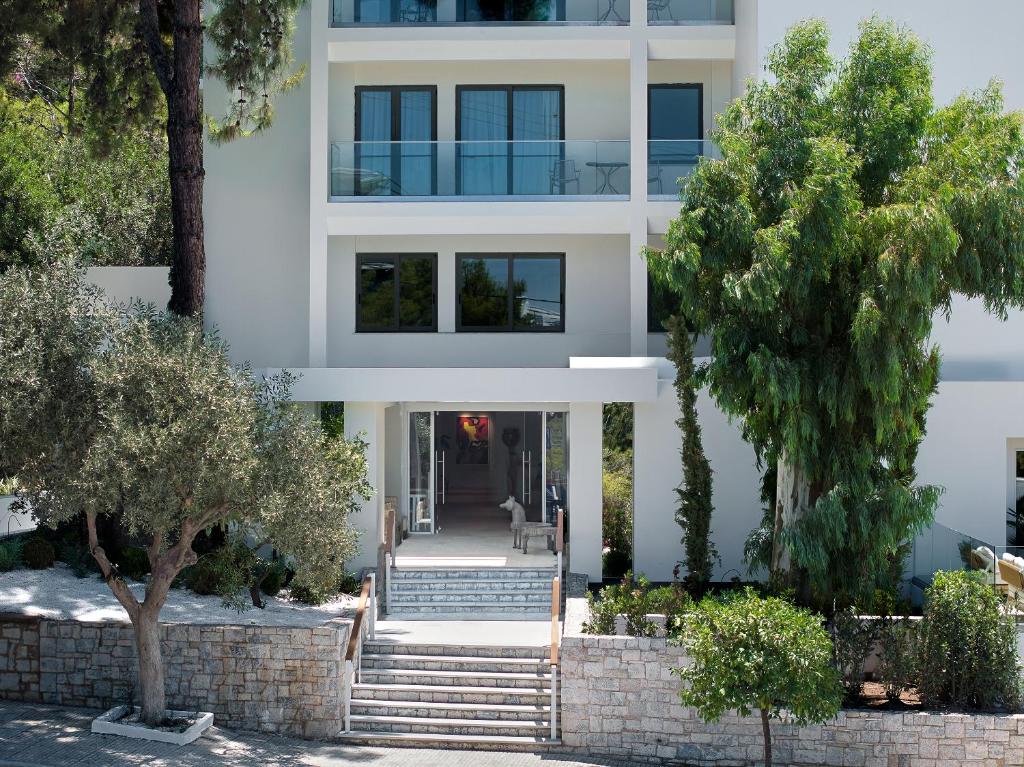 a white house with trees in front of it at The Roc Club, A Grecotel Hotel to Live in Athens
