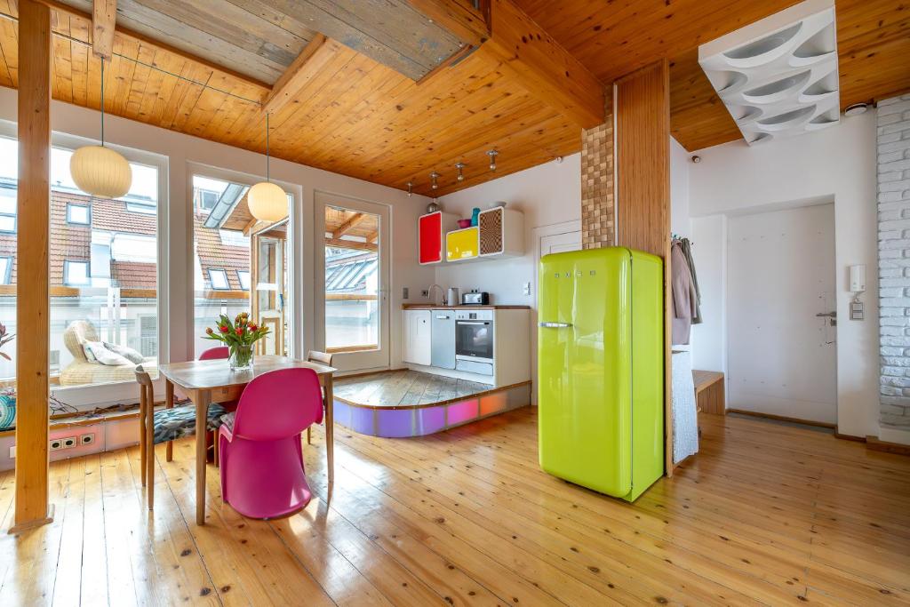 a kitchen with a table and a green refrigerator at Top floor Penthouse with Garden in Berlin