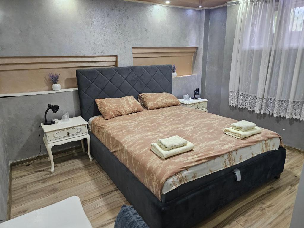 una camera da letto con un grande letto con due comodini di Prenociste Rooms Simke a Subotica