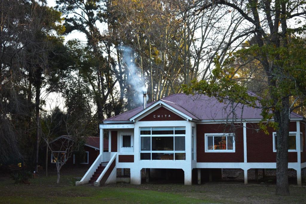 a red and white house with smoke coming out of it at Isla Chita in Tigre