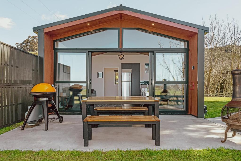 a shed with a picnic table and a grill at Black Label Retreats in Gisborne