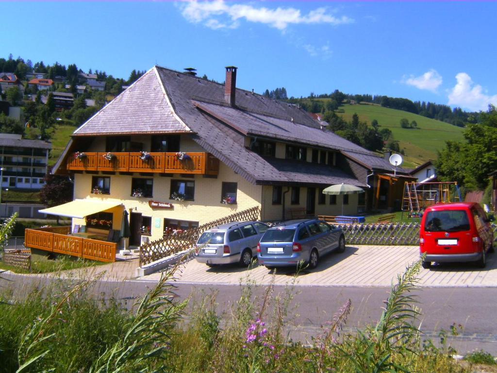 ein Gebäude mit Autos auf einem Parkplatz in der Unterkunft Haus Schöneck in Todtnauberg