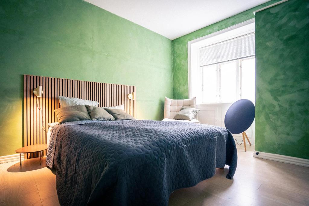 a green bedroom with a bed and a window at Spacious Green Apartment With Amazing Loft in Copenhagen