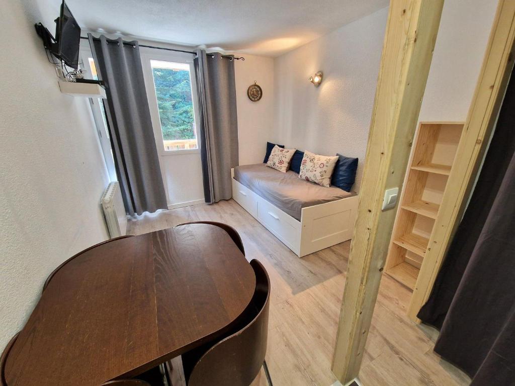 Cette petite chambre comprend une table et un canapé. dans l'établissement Studio cosy 4 pers avec balcon exposé Est, au pied des pistes - FR-1-265-238, à Valfréjus