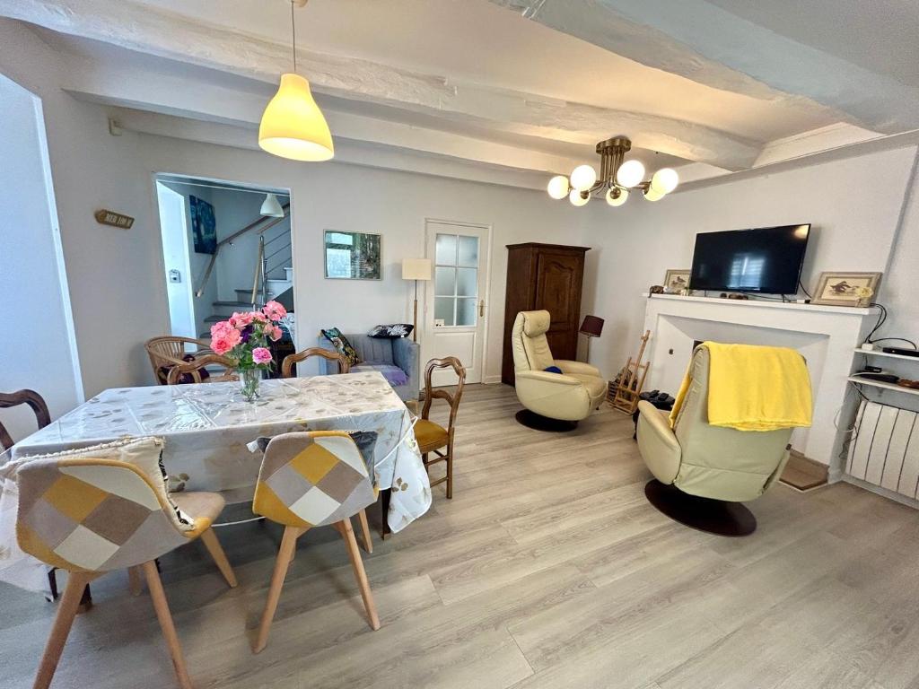 un salon avec une table et des chaises de salle à manger dans l'établissement Bienvenue Chez Bob dans le centre-ville de Vivonne, à Vivonne