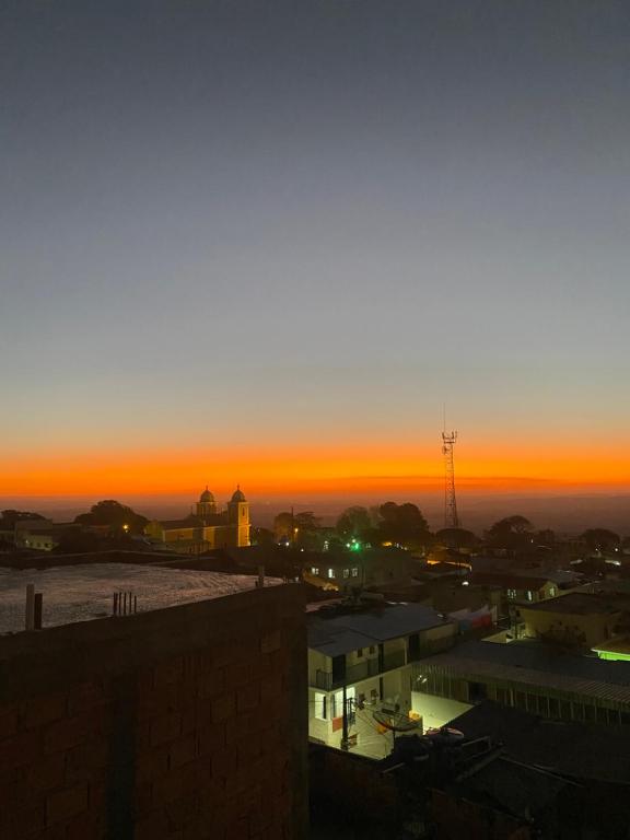 a sunset view of a city with a building at Kitnet pôr do sol in São Thomé das Letras
