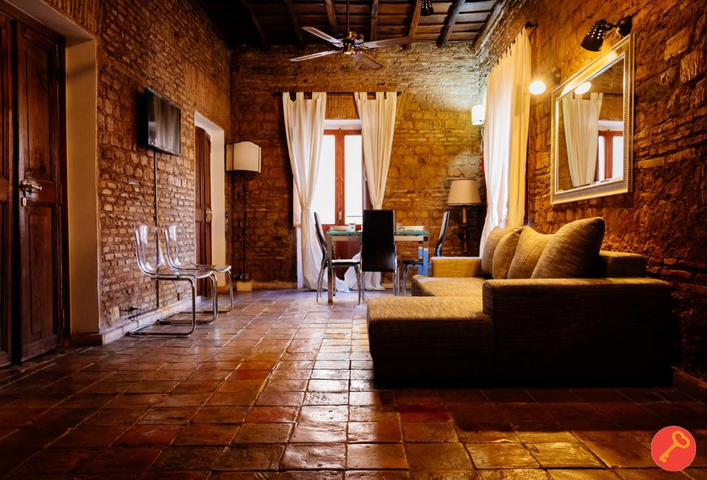 sala de estar con sofá y pared de ladrillo en Gorgeous House Trastevere, en Roma