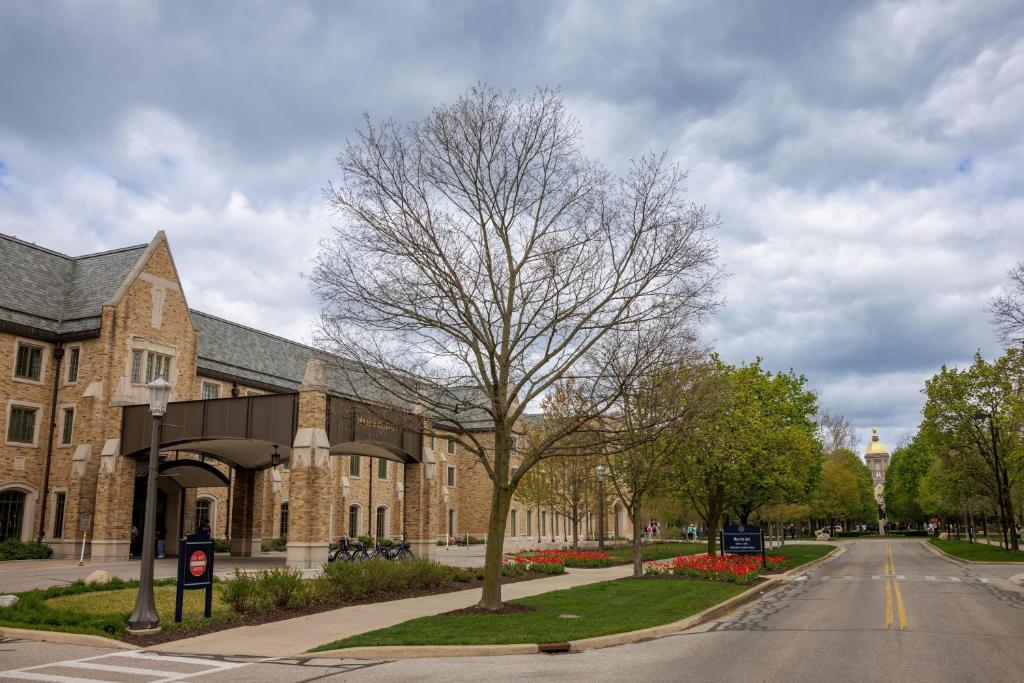 a building with a tree in front of a street at Morris Inn at Notre Dame in South Bend