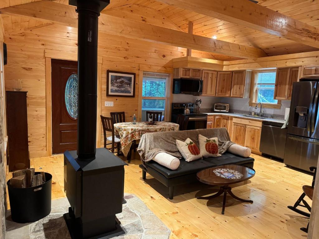 un salon avec un poêle à bois dans une cabane dans l'établissement Luxury Forest Lake House - Privacy, Nature, Conveniences - New 2 bedroom, à Windsor