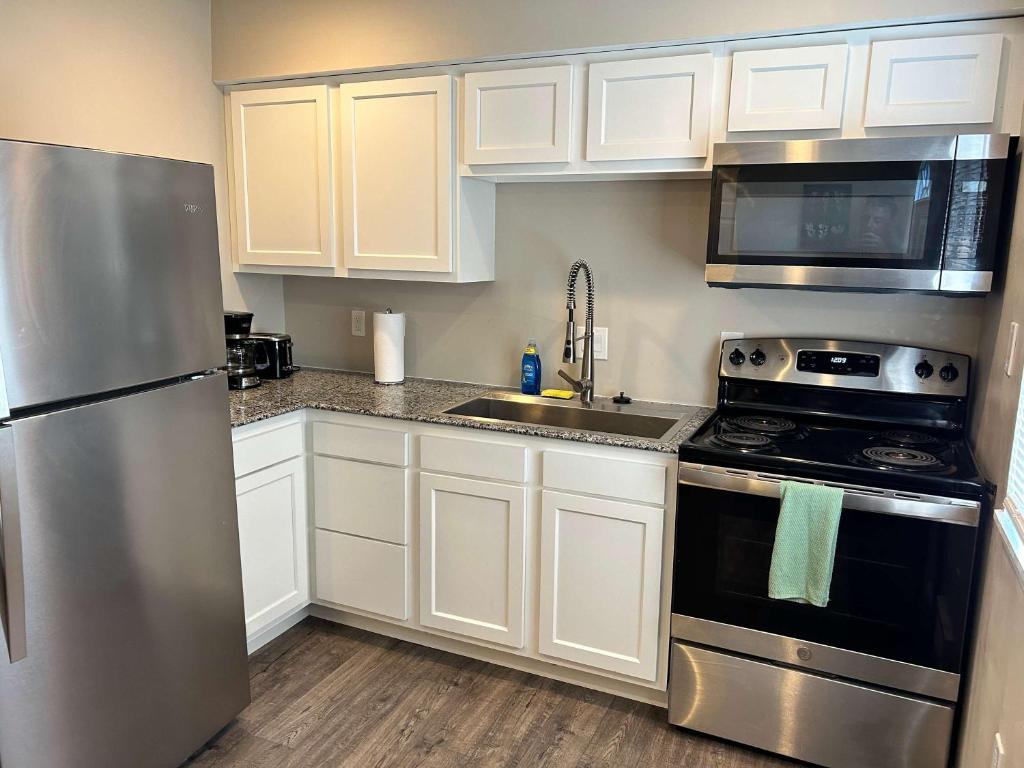 a kitchen with white cabinets and a stainless steel refrigerator at Carter #1 Two bedroom unit near Xavier Downtown in Cincinnati