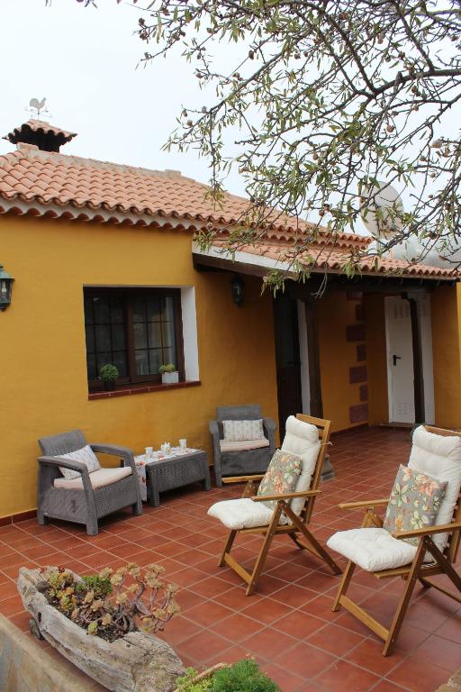 un patio con sillas y una mesa frente a una casa en La Casita de Ana, en Puntagorda