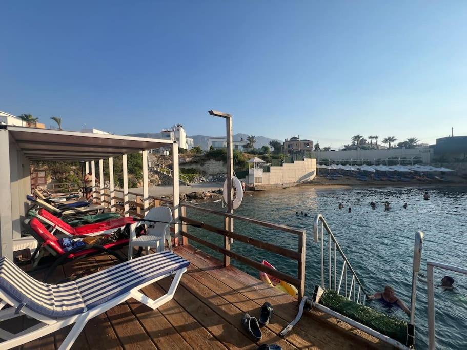 a dock with a couple of chairs and motorcycles on the water at Girne yazlık ev in Ayyorgi