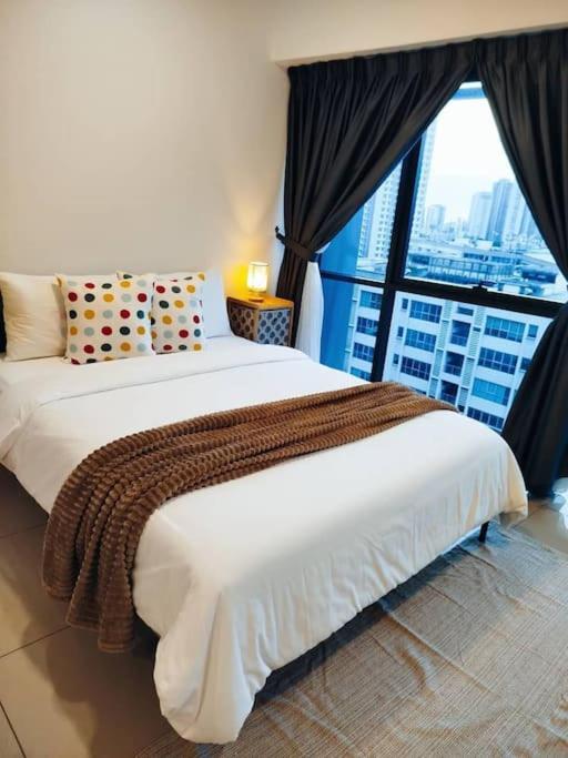 a bedroom with a large white bed with a large window at Cozy Haven Superior Studio Free Private Parking Netflix in Petaling Jaya
