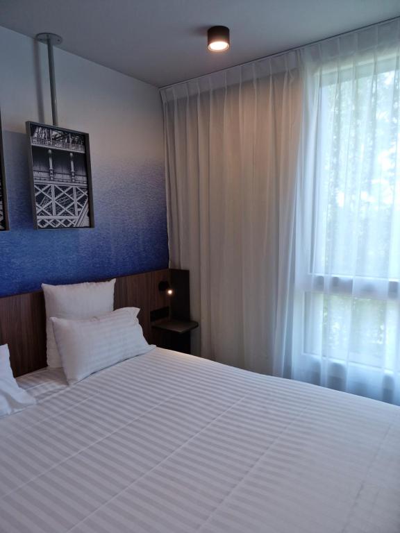 Hôtel AKENA Serris - Val d'Europeにあるベッド